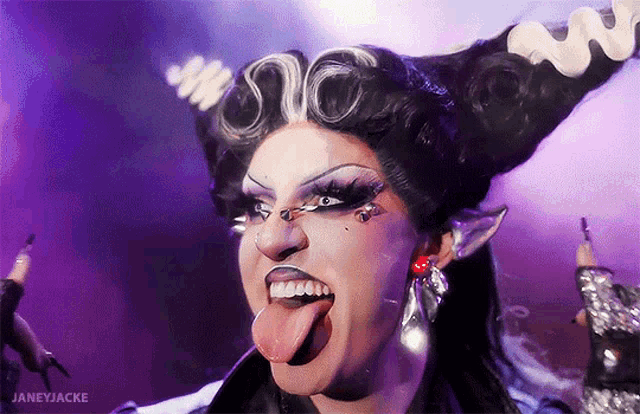 a drag queen is sticking her tongue out in front of a purple background