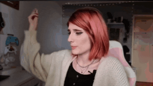 a girl with red hair is sitting in a pink chair