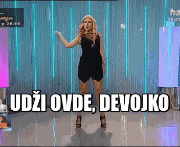 a woman in a black dress is standing in front of a sign that says odje ovde devojko