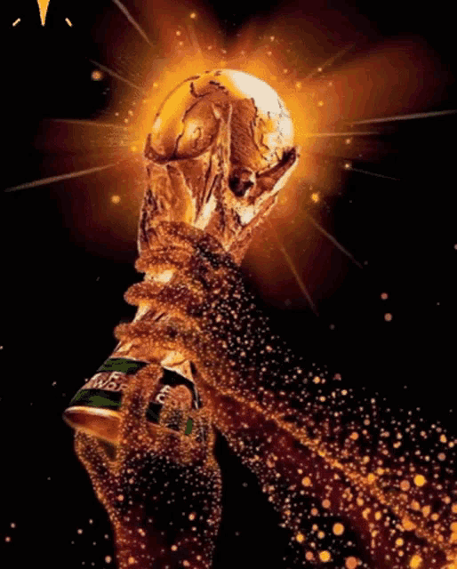 a hand holding a coca cola can with a soccer ball in the background