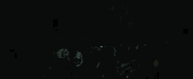 a group of people are dancing in a dark room with a green light .
