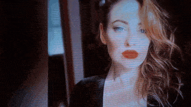 a close up of a woman 's face with red lipstick