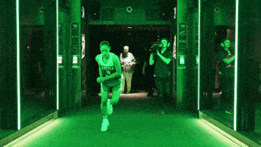 a basketball player with the number 4 on her jersey is running down a hallway