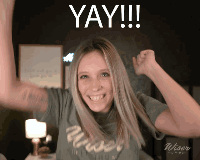 a woman with her arms in the air with the word yay written above her