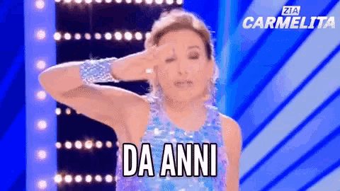 a woman in a blue sequined dress is saluting with the words da anni below her