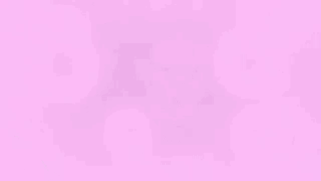 a man wearing glasses is sitting in a chair in front of a computer screen surrounded by pink bubbles .