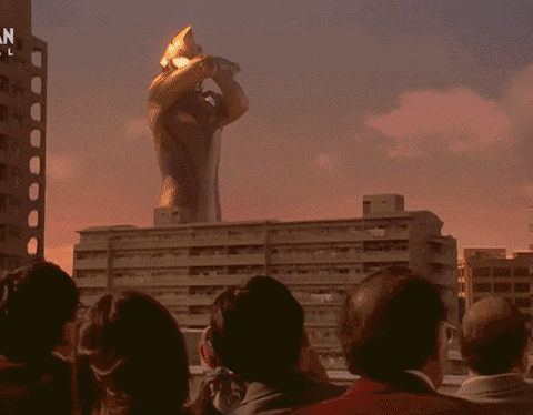 a man in a red superhero costume is flying through the air with a pink light coming out of his chest .