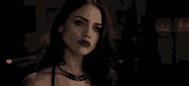 a close up of a woman wearing red lipstick and a black choker