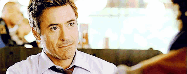 a man in a white shirt and tie is looking at something