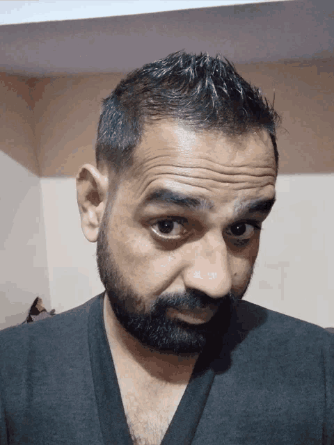 a man with a beard looks at the camera