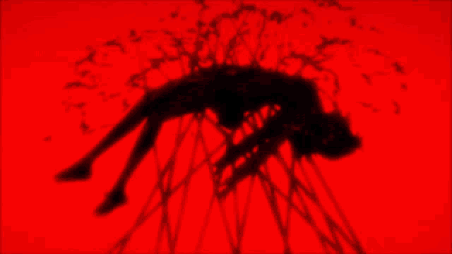 a red background with a silhouette of a person laying on the ground