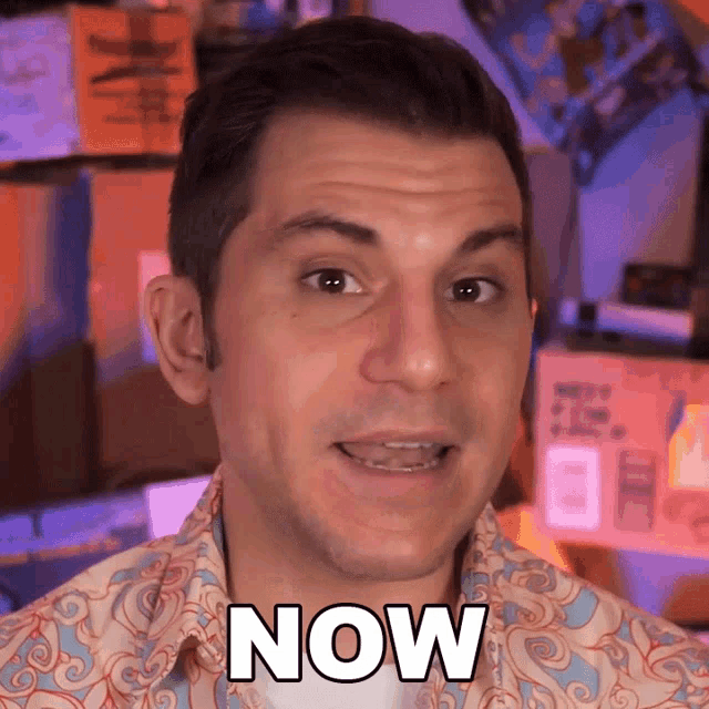 a man wearing a shirt with the word now on his chest