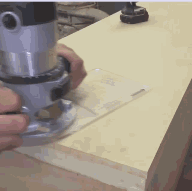 person using a router on a piece of wood