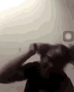 a man is taking a picture of himself in a mirror in a foggy room .