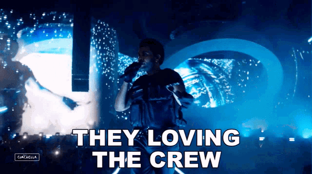 a man singing into a microphone with the words " they loving the crew " below him