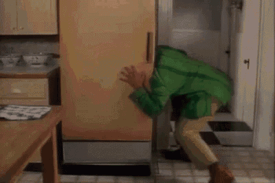 a person in a green shirt is laying in a closet .