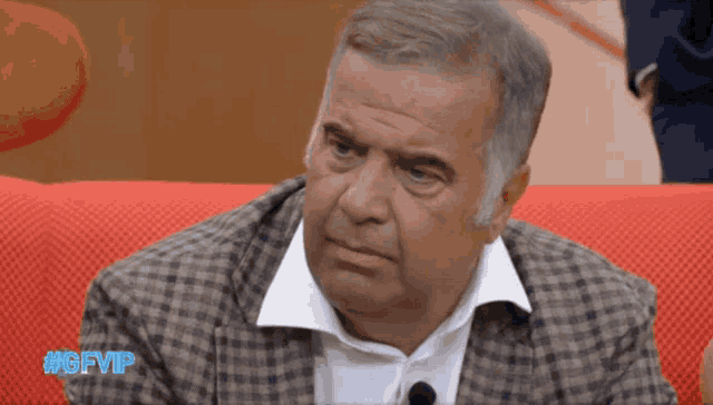 a man sitting on a red couch with the hashtag #gfvip on the bottom right