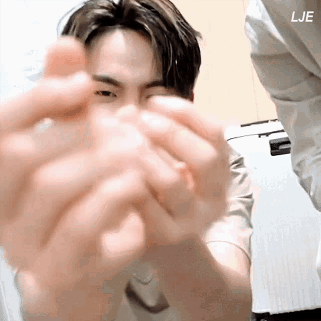 a close up of a person 's hands with the letters lje on the bottom right