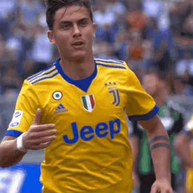 a soccer player wearing a yellow jeep jersey is running