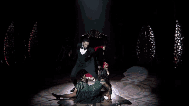 a man and a woman are dancing in front of a chair