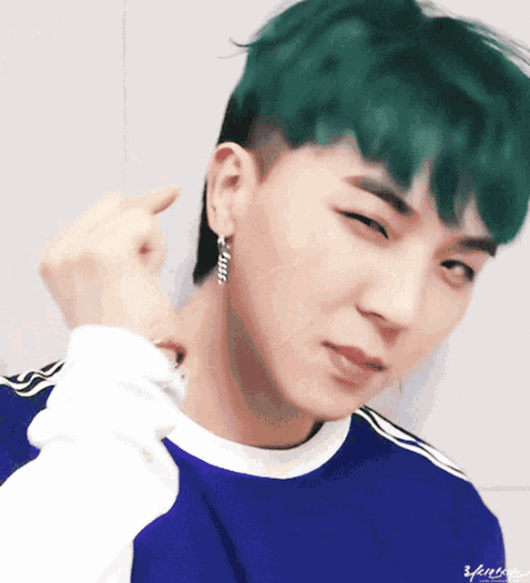 a close up of a person 's face with green hair