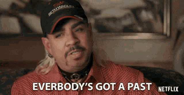 a man wearing a hat and a red shirt says everbody 's got a past