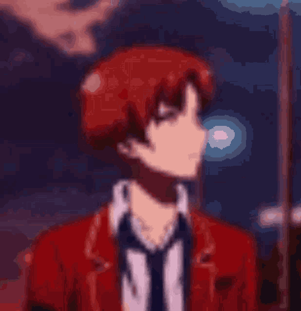 a man in a red suit and tie is standing in front of a dark background .