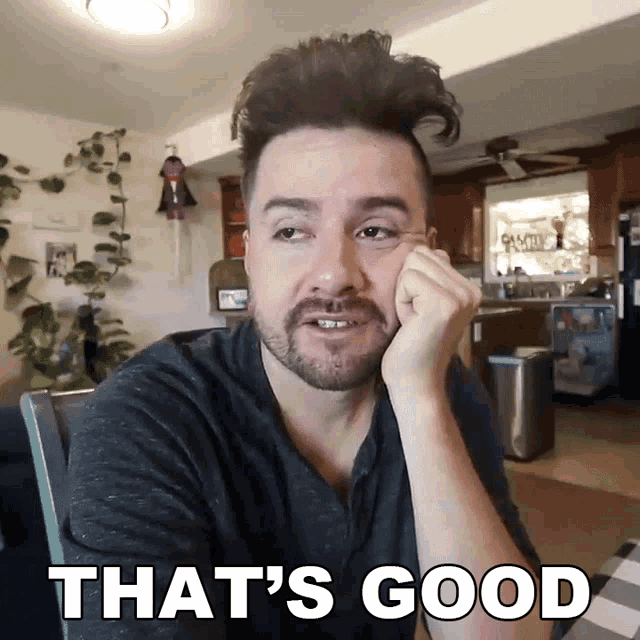 a man with a beard says that 's good in front of a kitchen