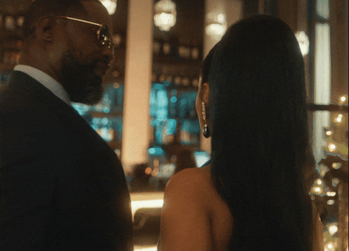 a man and a woman are looking at each other in a restaurant