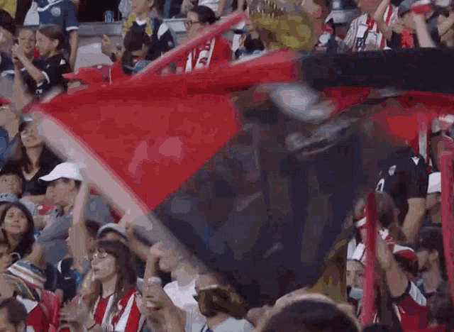 a crowd of people watching a soccer game with a statue in the middle that says ' coca cola '