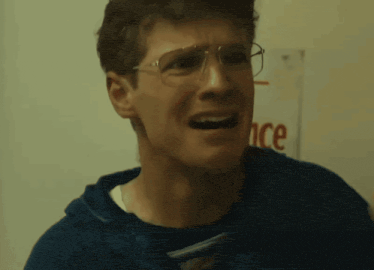 a man wearing glasses is making a funny face in front of a sign that says once