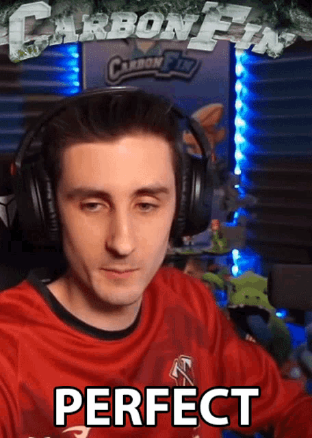 a man wearing headphones and a red shirt with the word perfect written on it
