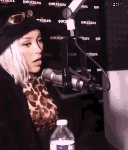 a woman is sitting in front of a microphone in a radio station .