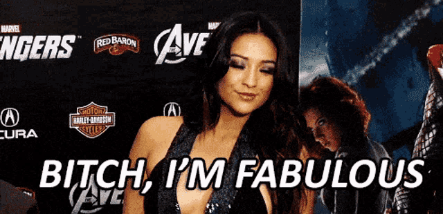 a woman standing in front of a sign that says " bitch i 'm fabulous "