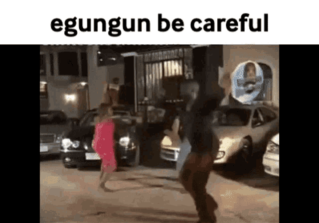a man and a woman are dancing in a parking lot in front of a building .
