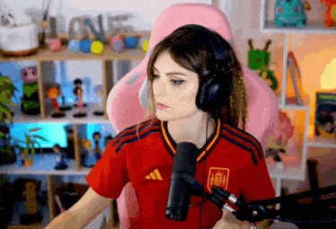 a woman wearing headphones and a red adidas jersey