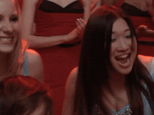 a woman in a blue dress is smiling in a crowd