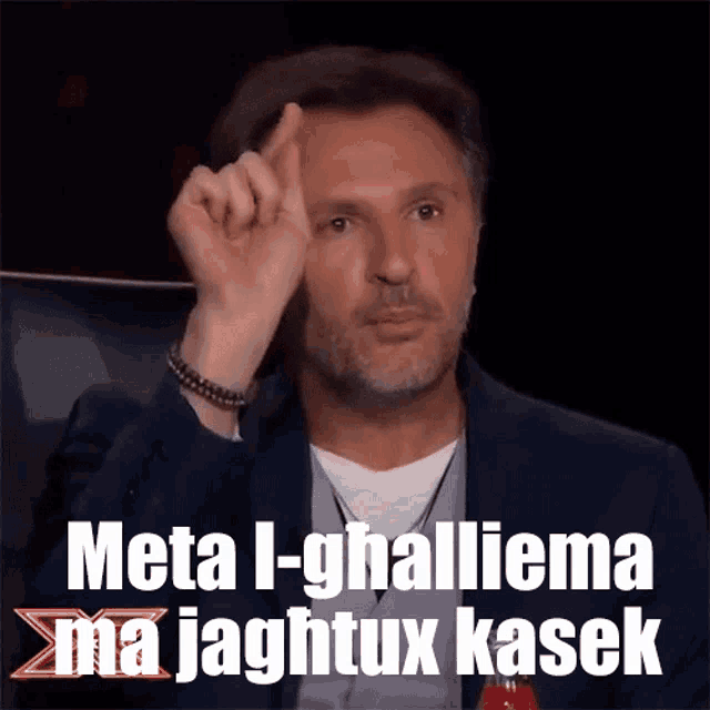 a man in a suit holds up his finger and says meta i-ghallema ma jaghtux kasek