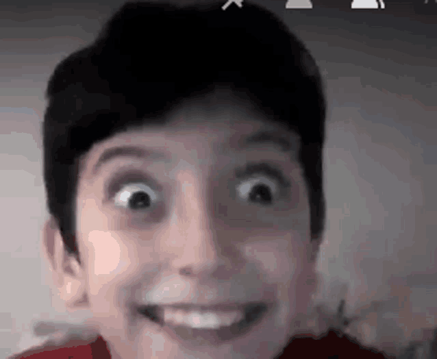 a close up of a young boy making a funny face .