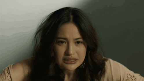 a close up of a woman 's face with a serious look on her face