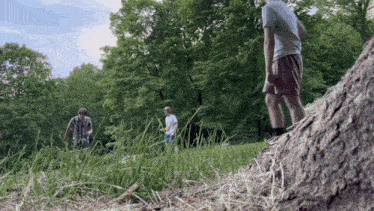 a group of people standing in a grassy field