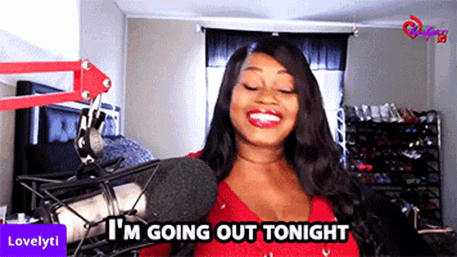 a woman is standing in front of a microphone with the words i 'm going out tonight above her