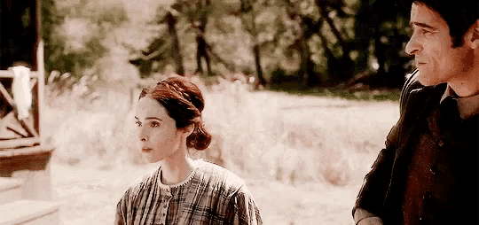 a man and a woman standing next to each other in a field .
