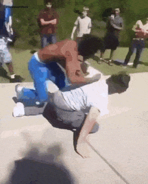 a group of people are watching a man kneeling down on the ground