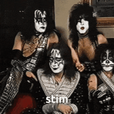 a group of kiss members are posing for a picture in a room .