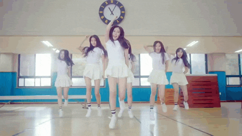 a group of girls are dancing in front of a clock that shows the time as 4:20