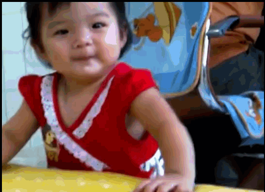 a little girl wearing a red top is sitting at a table