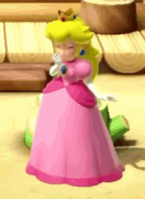 princess peach is wearing a pink dress and holding a microphone while standing on a sandy surface .