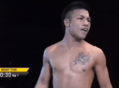 a man is standing in a boxing ring with the time 2:26