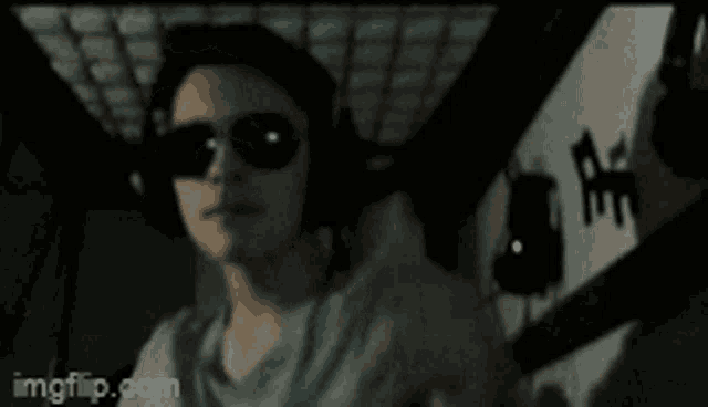 a blurry picture of a woman wearing sunglasses and headphones with imgflip.com in the lower right corner